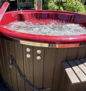 a hot tub filled with water next to a bench at Strazdiņi in Saraiķi
