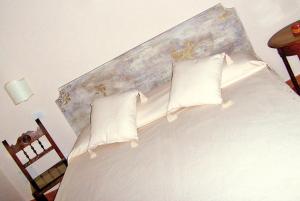 a bedroom with a white bed with a head board at Casale Del Colle | Perugia in Collestrada