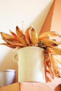 a white vase with ears of corn in it at Casale Del Colle | Perugia in Collestrada