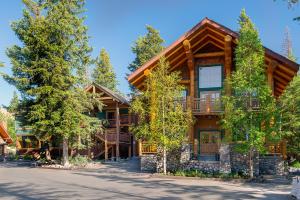 a large log home with trees in front of it at Buffalo Mountain Lodge in Banff