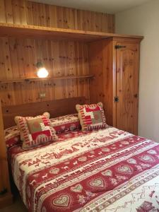 a bedroom with a bed with a red and white blanket at B&B La Vieille Meison de Pappa in Aosta