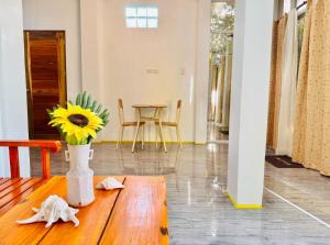 eine Vase mit einer Sonnenblume auf einem Holztisch in der Unterkunft Narra Villas Soft Opening Promo Get Entire Unit in General Luna