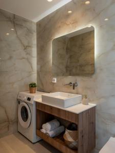 a bathroom with a sink and a washing machine at Salty Dreams in Piso Livadi