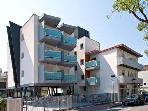 un edificio con balcones al lado de una calle en Hotel Simi Lan, en Lignano Sabbiadoro