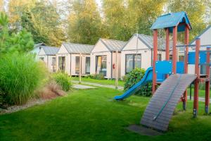 a playground in front of a row of houses at UMILI Pod Cyprysami - surf & family resort in Jastarnia
