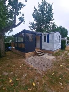 een blauw en wit tiny house in een yard bij Bungalow, 3 chambres in La Bernerie-en-Retz
