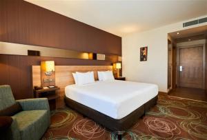 Un dormitorio con una gran cama blanca y una silla. en Dedeman Park Gaziantep Oteli, en Gaziantep 42 fotos más