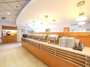 un restaurant avec un comptoir avec des assiettes dessus dans l'établissement Ibis Chengdu Yongfeng Hotel, à Chengdu