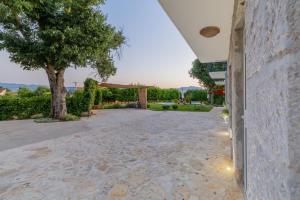 an empty driveway with a tree and a building at Villa Lavandis with Jacuzzi and 50m2 Pool in Donji Vinjani +41 photos