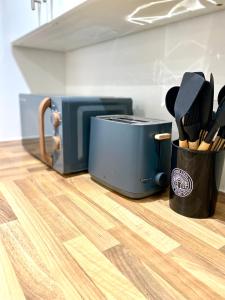 een aanrecht met een broodrooster en een container met keukengerei bij Luxurious 2 Bedroom - Water View and Parking in Manchester