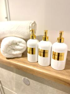 drie flessen zeep op een plank in de badkamer bij Luxurious 2 Bedroom - Water View and Parking in Manchester
