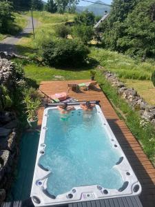 two people in a swimming pool in a backyard at Chez Mary Elise in Le Claux