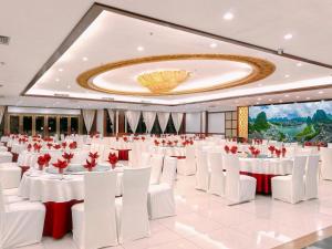 a large banquet hall with white tables and white chairs at Yangshuo Greenlotus Hotel in Yangshuo +95 photos