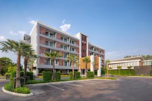 a building with palm trees in a parking lot at The Canal 304 in Si Maha Phot