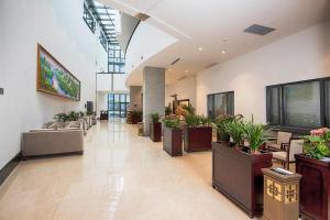 a hallway with potted plants in a building at Huading International Hotel in Hangzhou