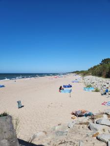 a beach with people laying on the sand and the ocean at Pokoje Gościnne u Marcina, Gästezimmer bei Martin in Mielno +9 photos