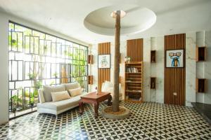 un salon avec un canapé et un arbre dedans dans l'établissement K.K inn Boutique Siem Reap, à Siem Reap