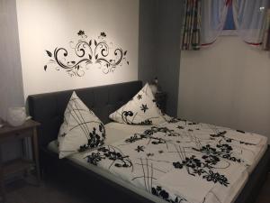 uma cama com lençóis e almofadas preto e branco em Ferienwohnung Klinkhammer em Ripsdorf