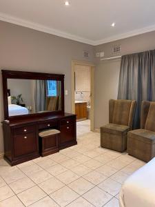 a bedroom with a bed and a mirror and chairs at Tranquility in Margate +23 photos