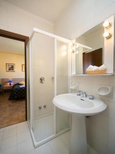 a white bathroom with a sink and a shower at Albergo Centrale in San Zeno di Montagna