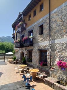 a building with tables and chairs in front of it at HOTEL RURAL EL SABINAR in Crémenes
