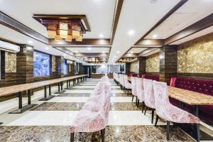 a row of tables and chairs in a restaurant at Palette Alandur Near Chennai Airport in Chennai