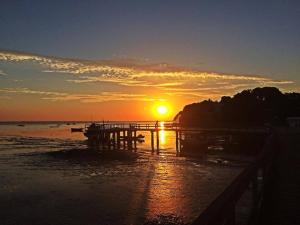 a sunset on the beach with the sun setting at pousada do rei in Pedra de Guaratiba