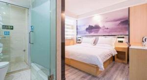 a bedroom with a bed and a bathroom with a shower at GreenTree Alliance Jiangsu Nanjing Pukou District Zhongsheng Street Wende Road Metro Station Hotel in Pukou
