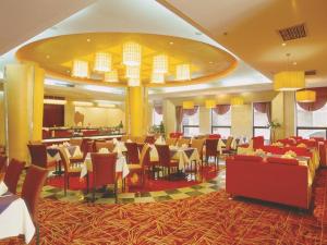 ein Speisesaal mit Tischen und Stühlen in einem Restaurant in der Unterkunft Xian Union Alliance Atravis Executive Hotel in Xi'an