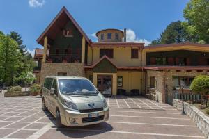 un'auto parcheggiata in un parcheggio di fronte a una casa di Albergo della Posta a Taverna