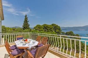 a table and chairs on a balcony with a view of the water at Apartment Lujak in Koločep