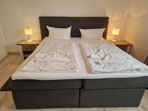 a bed with white sheets and pillows on it at Villa Monika Steuerbord 5 in Sassnitz