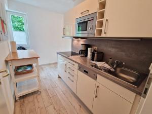 a kitchen with a sink and a microwave at Villa Monika Steuerbord 5 in Sassnitz +4 photos