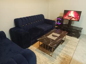 a living room with a blue couch and a coffee table at BNB Makutano Meru in Meru