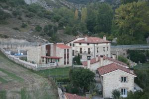 a large house on a hill next to a mountain at Casa Rural Torres in Valdenoceda