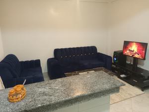 a living room with two blue couches and a tv at BNB Makutano Meru in Meru