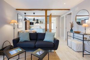 a living room with a blue couch and a kitchen at La Gaitona d'Aller - Cabañaquinta in Aller