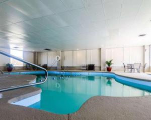 a large swimming pool with blue water in a building at SureStay Hotel in Salina