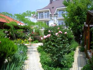 a garden in front of a house with pink roses at Mechta in Koktebel