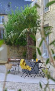 een tafel en stoelen voor een gebouw bij La Maison de Mathilde in Bayeux