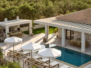 ザキントスにあるOlithera Villa, Private Pool & 1acre Green Land, By ThinkVillaのスイミングプールと傘付きの家屋の空中ビュー