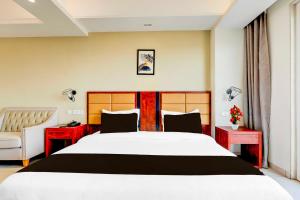 a bedroom with a large white bed and two red tables at Collection O Sector 39 Medanta in Gurgaon