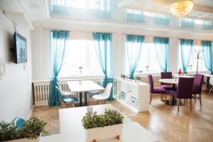 ディミトロフグラードにあるMini-Hotel Skazkaのダイニングルーム(青いカーテン、テーブル、椅子付)