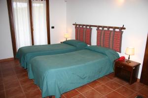 a bedroom with two beds and a table with lamps at Agriturismo Simonello in Stignano