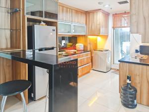 ジャカルタにあるLuxury 3BR Casa Grande Apt with Wi-Fi, Gym, Pool by 2ndHomeのキッチン(黒いカウンター、冷蔵庫付)