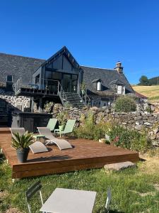 a house with a deck with chairs on it at Chez Mary Elise in Le Claux