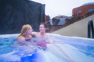 a man and a woman in a hot tub at Chester Apartments in Chester