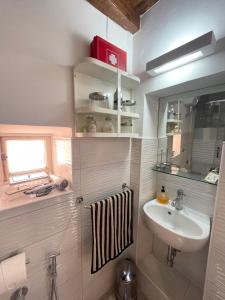 a small bathroom with a sink and a mirror at Romantic House in Trevignano Romano