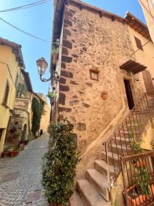 an old stone building with stairs leading down a street at Romantic House in Trevignano Romano