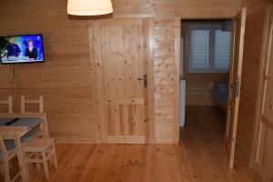 a room with a door and a tv on a wall at Domki u Ani Rusinowo in Rusinowo